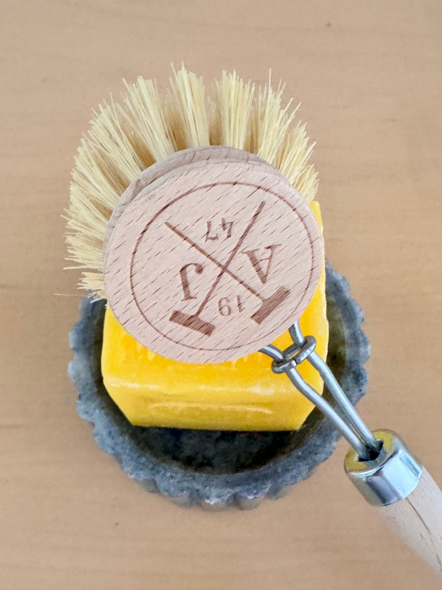 Cleaning brush with a wooden handle and bristles on a cardboard background